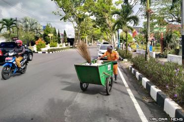 Seorang pegawai DLH Bukittinggi, Efison tengah menunaikan...