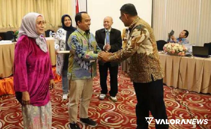 Ketua DPRD Padang, Syafrial Kani menyerahkan tanda peserta Bimtek pada anggota DPRD Padang, Muharlion.