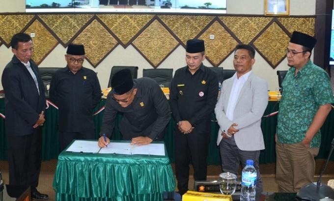 Ketua DPRD Padang, Syafrial Kani didampingi wakil ketua Arnedi Yarman dan Ilham Maulana tandatangani nota persetujuan Perda PPA Tahun 2022 usai rapat paripurna, Jumat malam.
